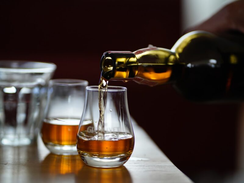 photo of person holding glass bottle