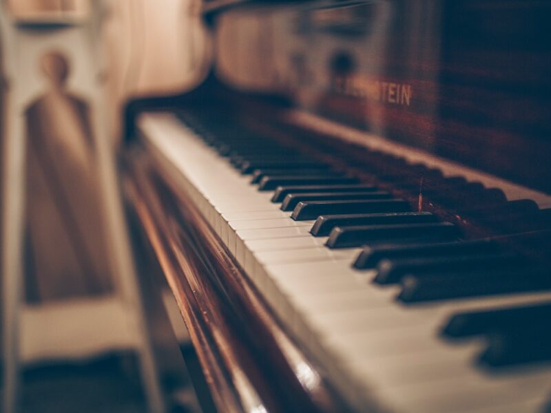 a close up of a piano with a person in the background