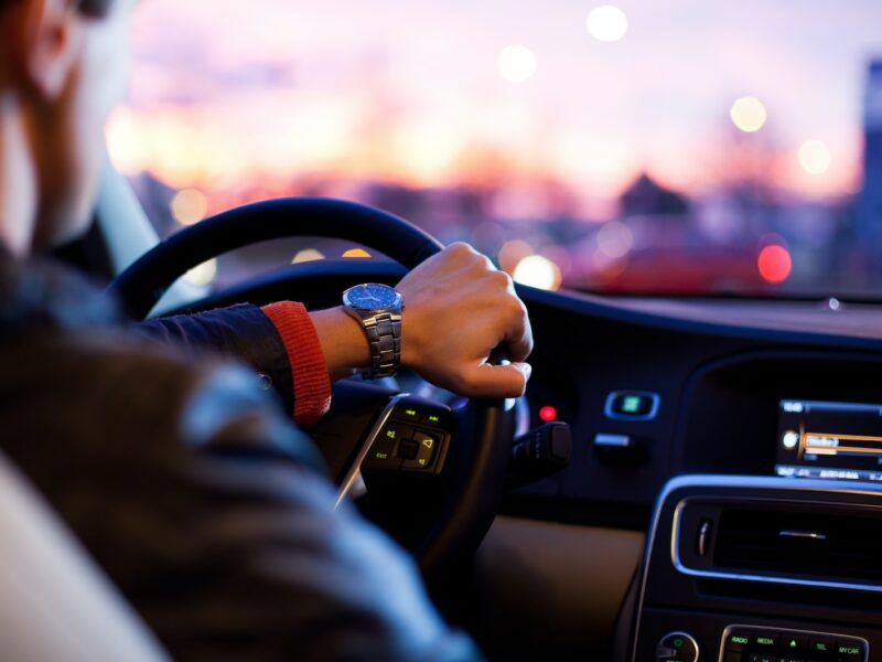 man driving a car wearing wrist watch