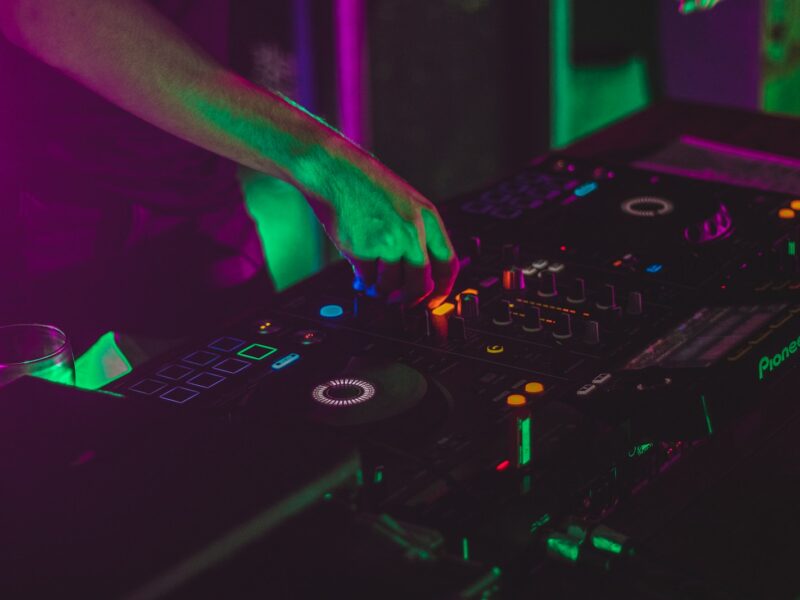 person playing dj controller in a dark room