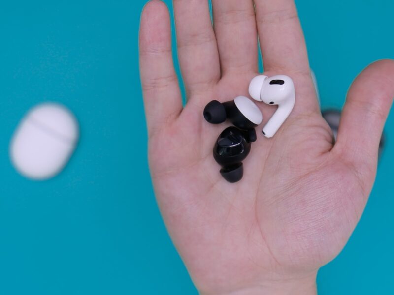 white and black earbuds on persons hand