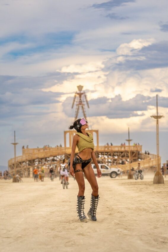 Woman in festival attire near large wooden structure
